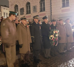 Przedstawiciele służb mundurowych składający wiązankę i znicz pamięci przed pomnikiem Grobu Nieznanego Żołnierza