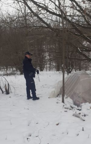 policjant podczas kontroli namiotu rozbitego w zagajniku leśnym