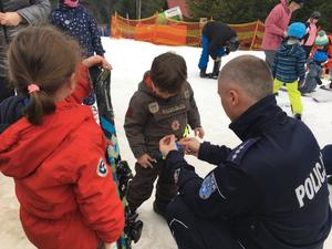 policjant rozdający odblaski dzieciom