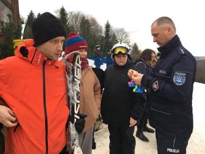 policjant na stoku z narciarzami